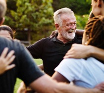 Dentures patient in New Bedford smiling with friends