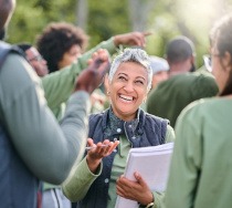 Woman smiling while talking to coworkers outside